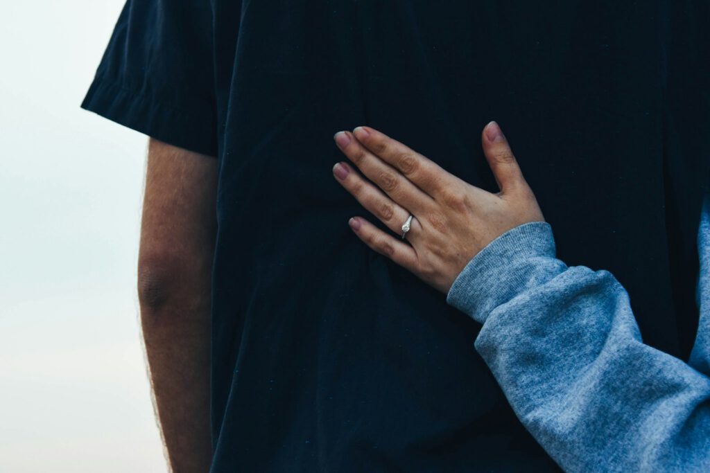 Eine Hand liegt tröstend auf der Schulter eines Menschen