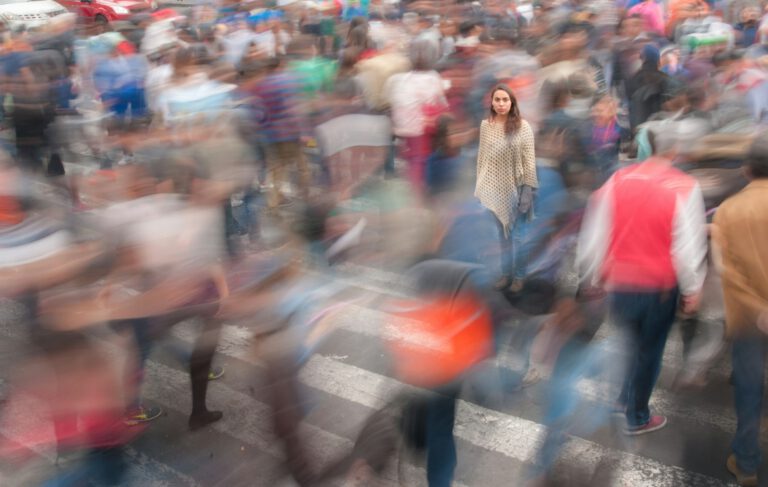 Viele Menschen gehen tagsüber eine belebte Straße entlang