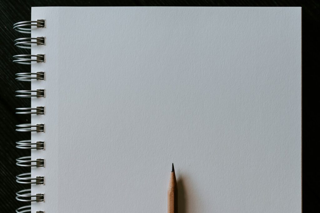 Bleistift liegt auf einem weißen Blatt Papier