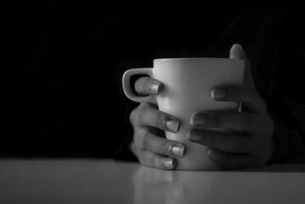 Hände halten eine warme Kaffeetasse