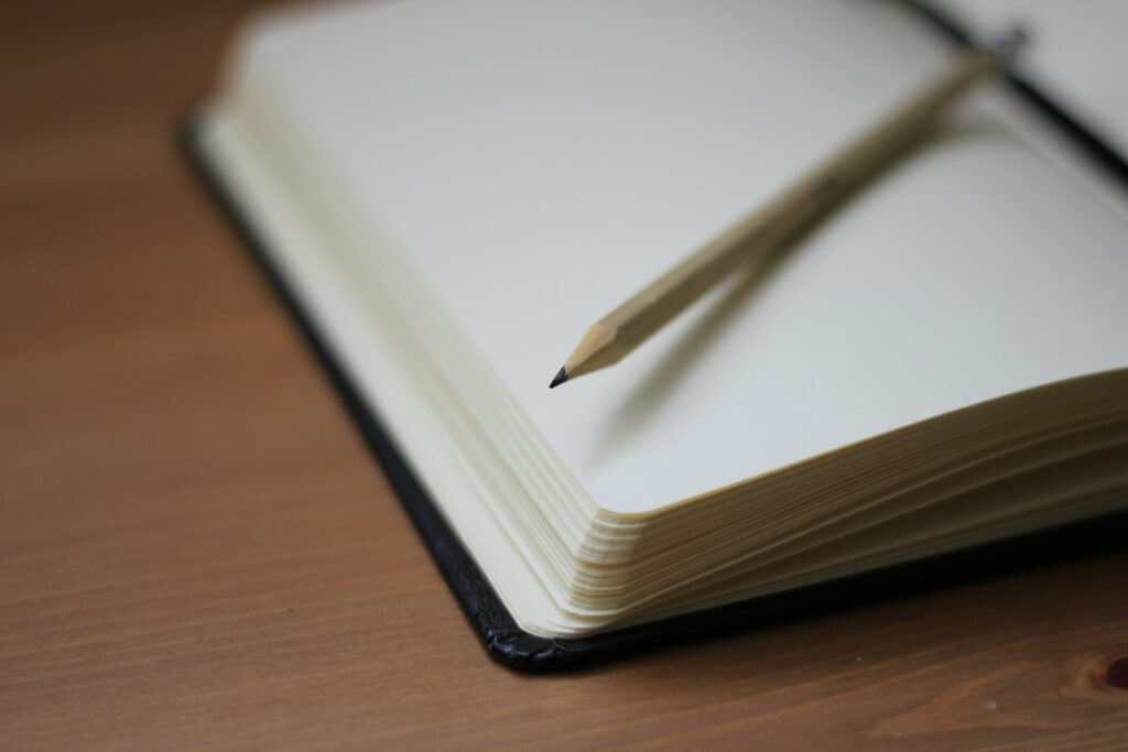 Bleistift liegt auf einem aufgeschlagenen Notizbuch